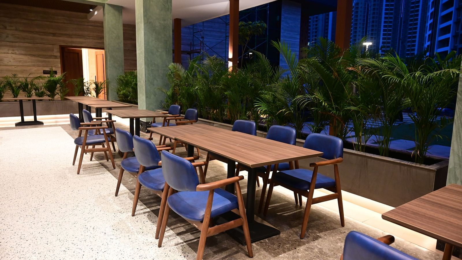 a huge dining table at citrus restaurant and cafe with six blue cushioned chairs around it