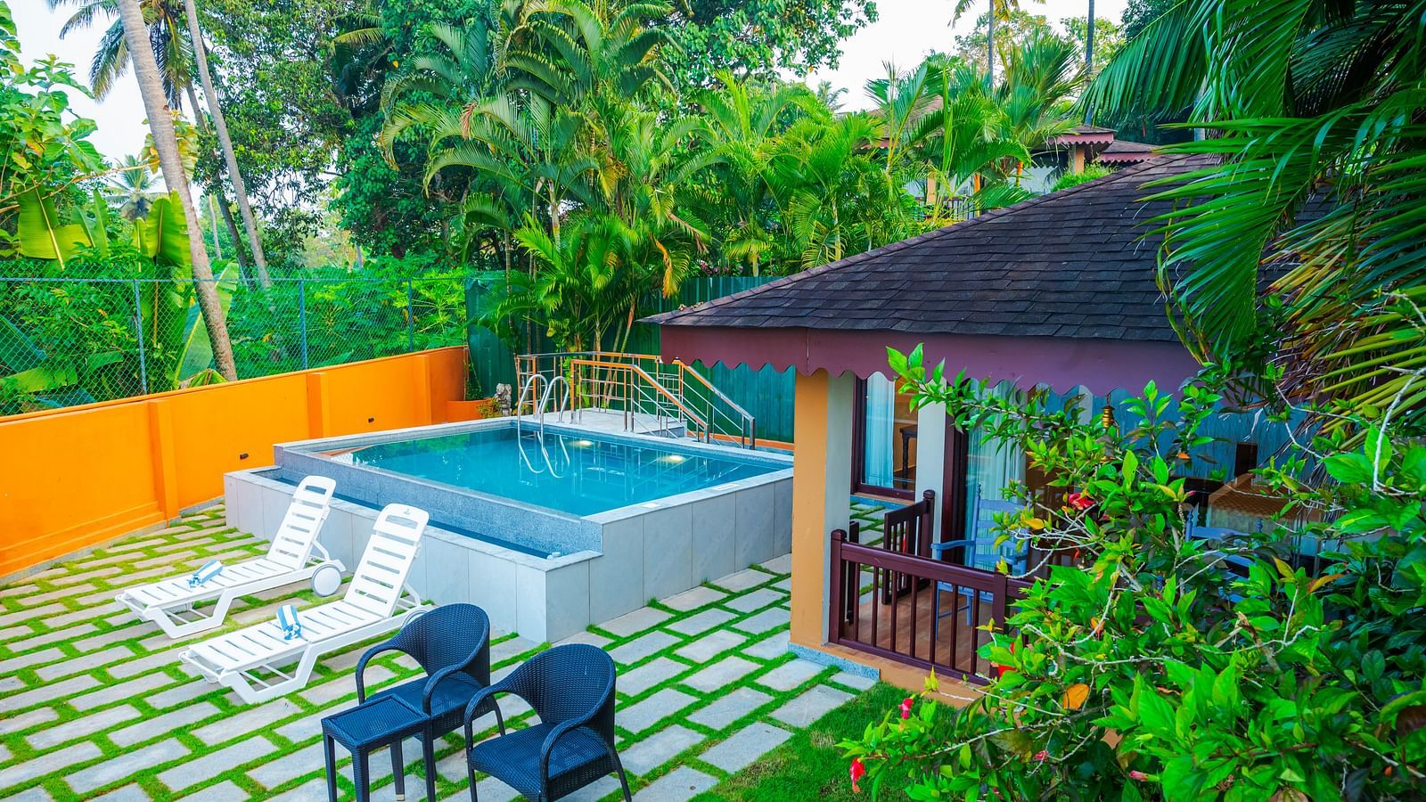 Cottage with a private pool and lush greenery at a resort.