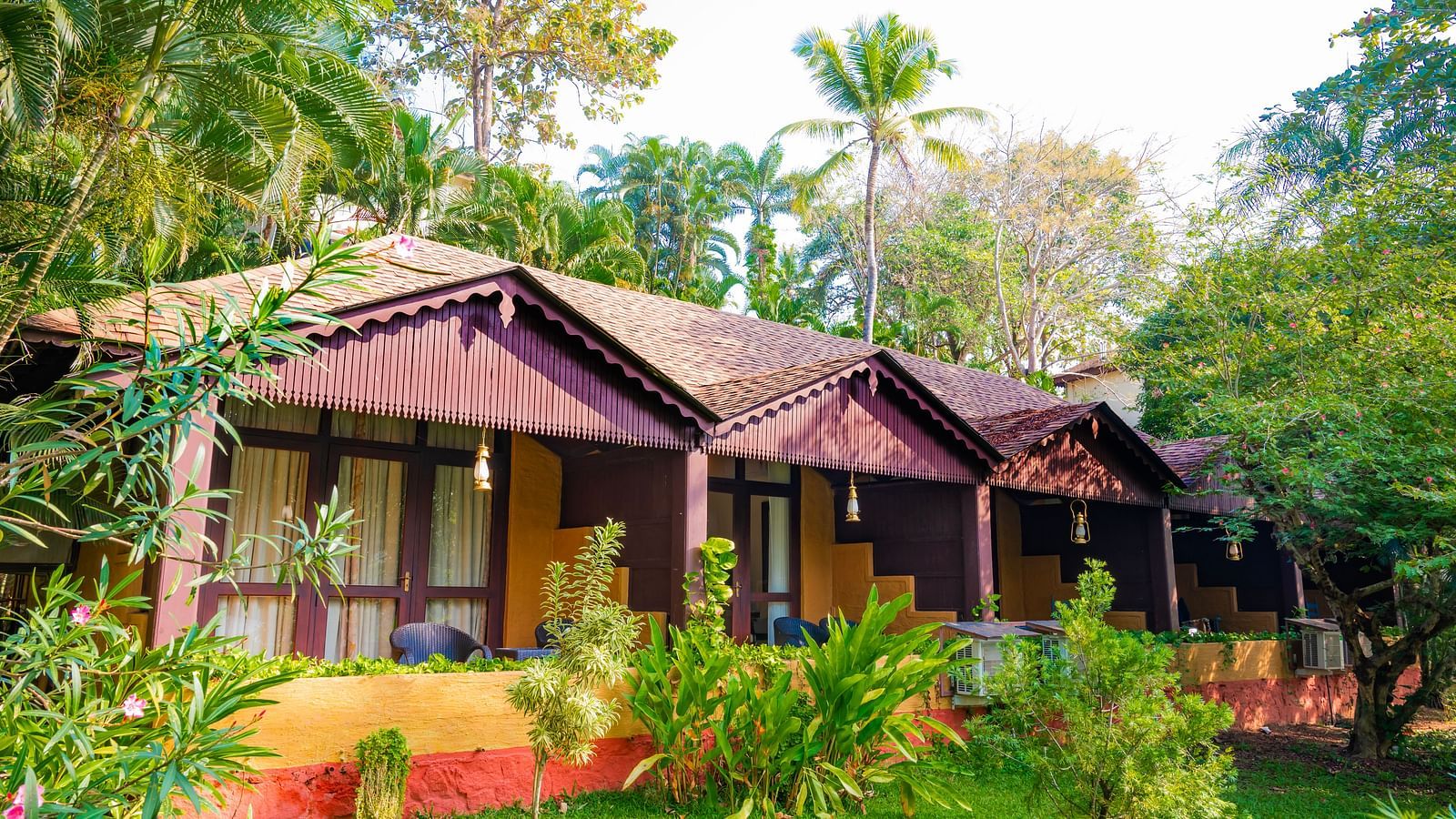 Cottages nestled amongst lush greenery with a view of the lake at a resort.
