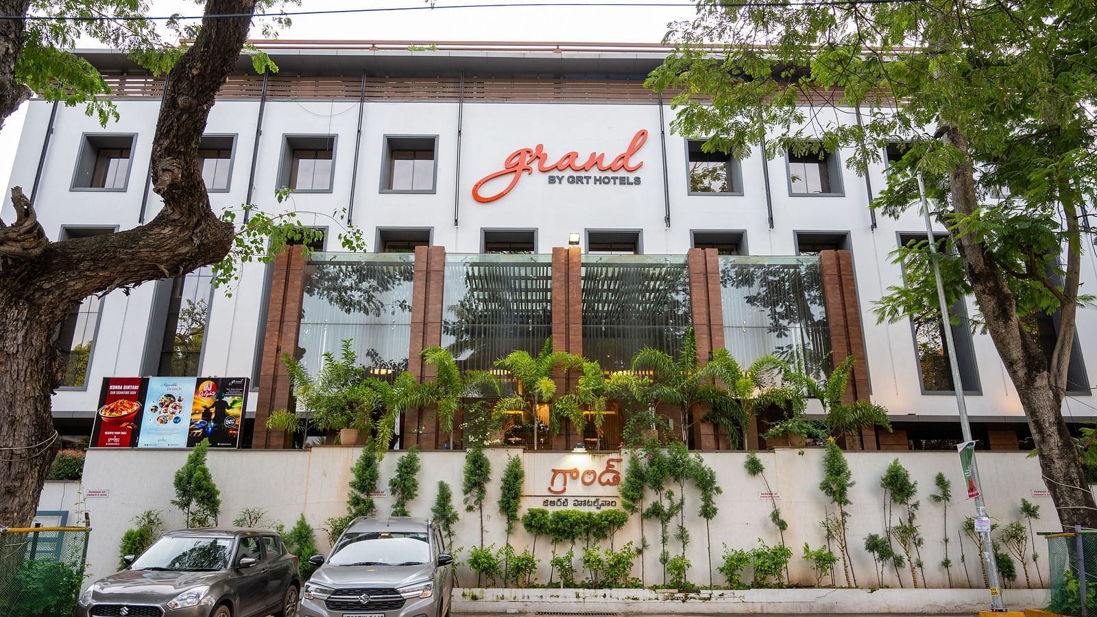 parking space of Grand Kakinada by GRT Hotels covered with plants and trees