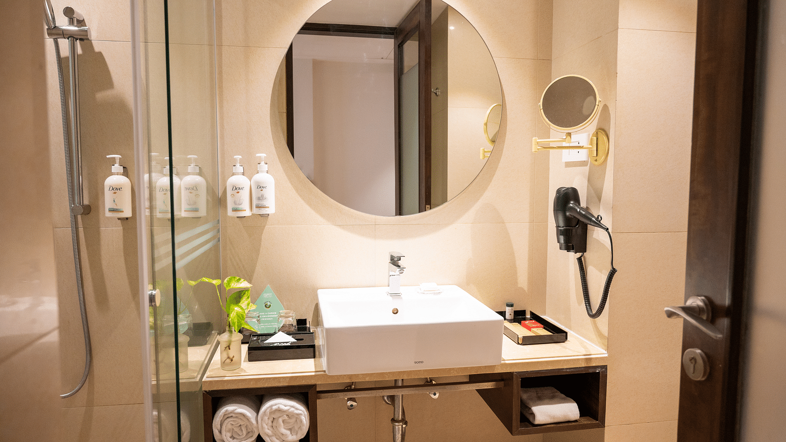 an image of bathroom with a mirror and toiletries at Grand Kakinada by GRT Hotels