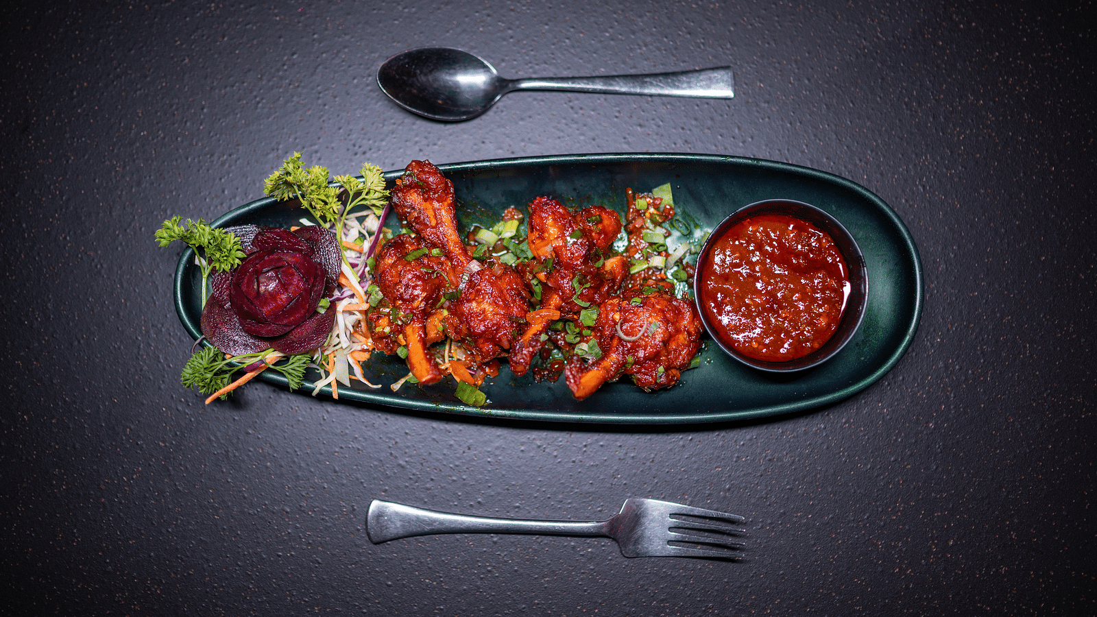 A top view of a juicy and delicious starter served with sauce and cutlery, beautifully presented at Hotel Moti Palace