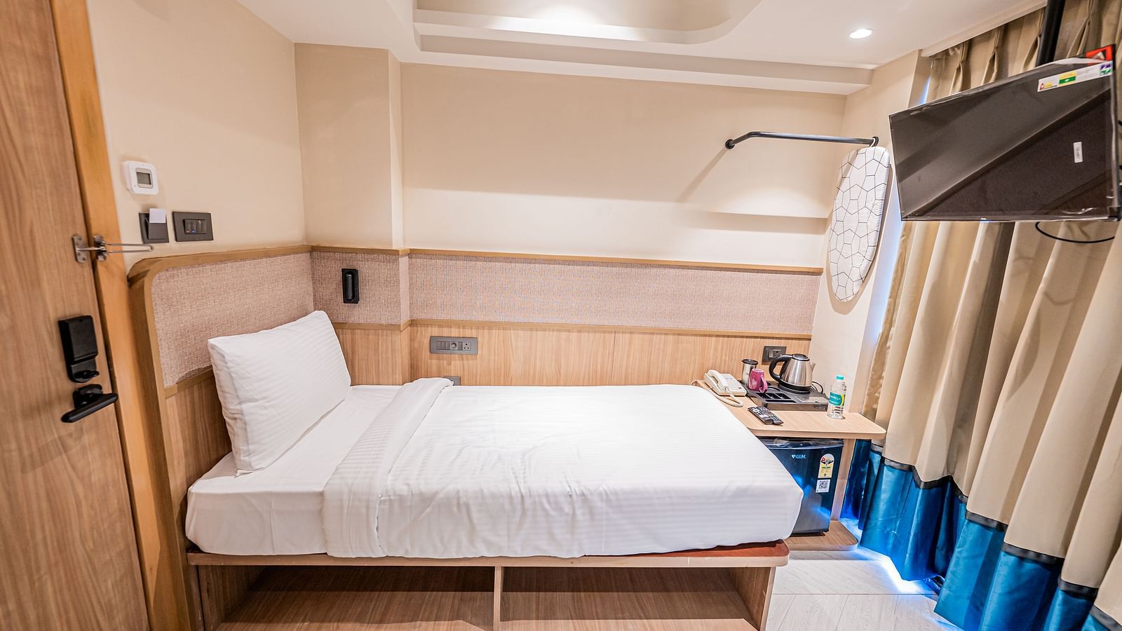 Size view of a spacious room with large bed and warm lighting at Indie Stays Mumbai International Airport.