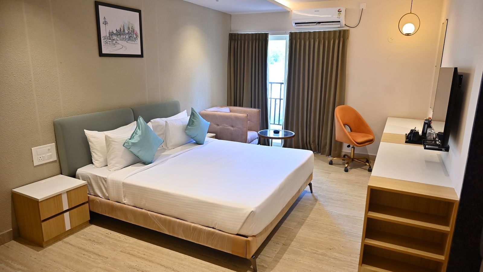 Bright and airy premium room with a big bed, soft chairs, and curtains over large windows, offering plenty of light and modern features at TGI Livancia Hillside