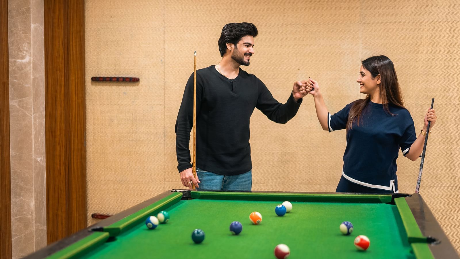  Couple engaging in a friendly billiards game at The Grand Legacy Resort and Spa.