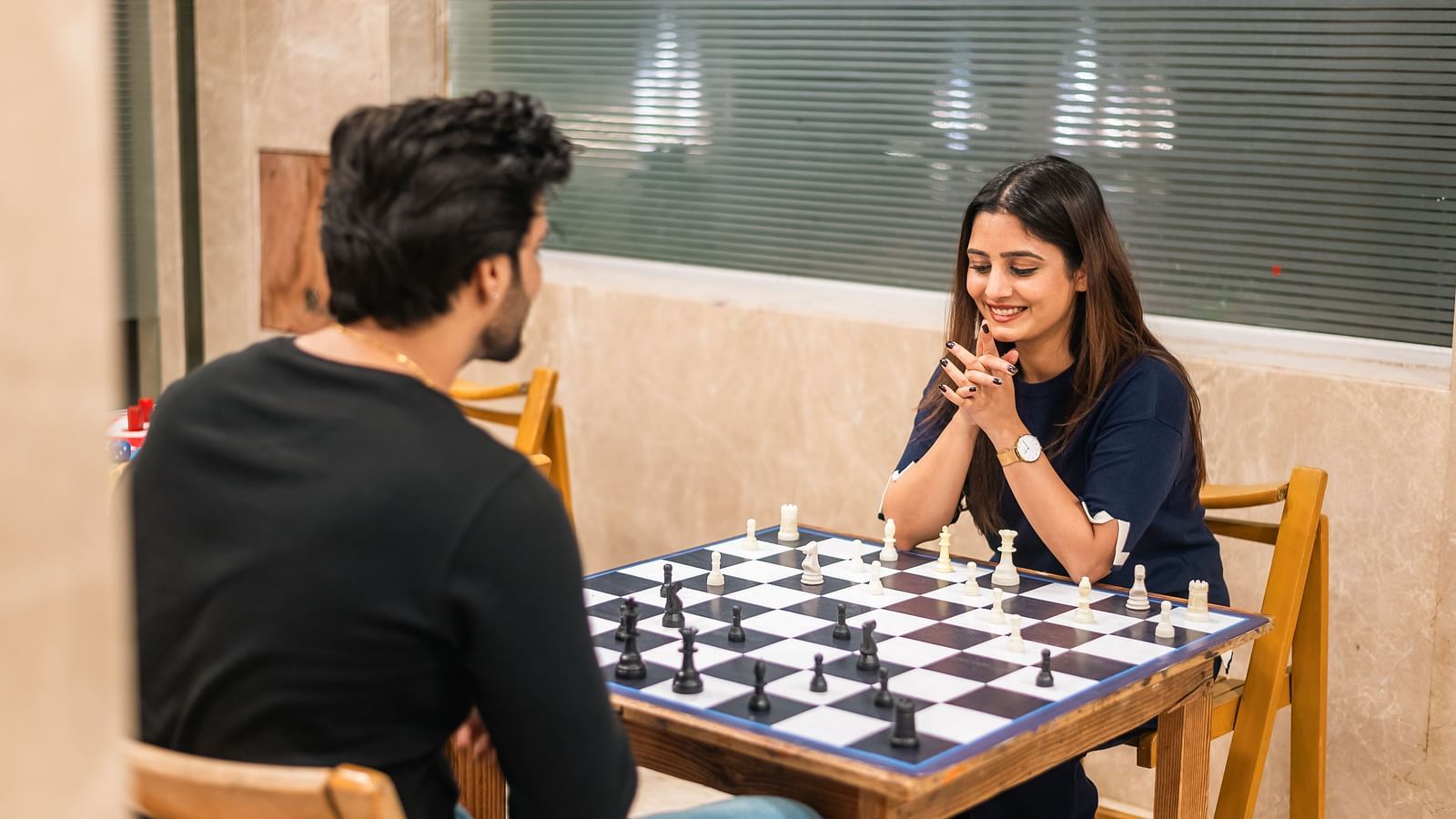  Guests playing a game of chess, enjoying relaxing indoor activities at The Grand Legacy Resort and Spa.