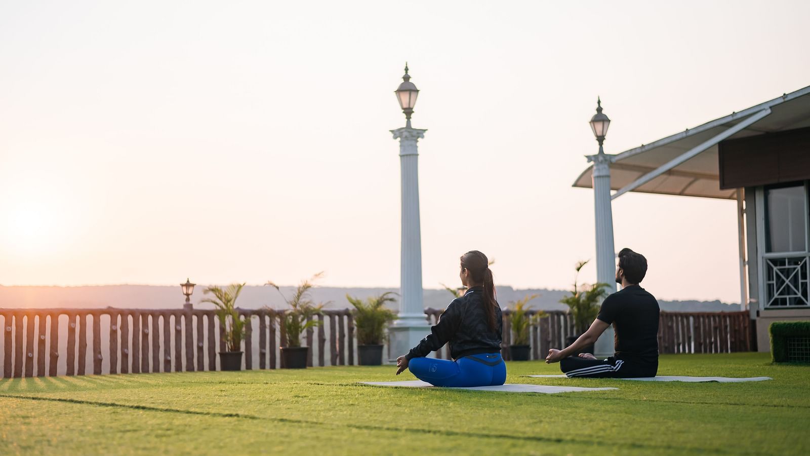  Guests relaxing on the lawn at sunset, enjoying the peaceful outdoor setting at The Grand Legacy Resort and Spa.