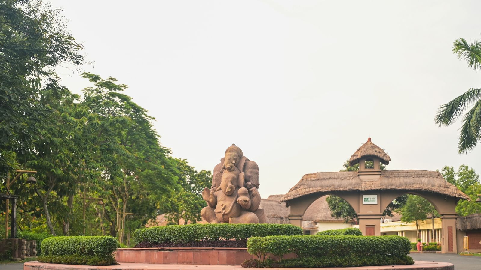 The entrance to Vedic Village Spa Resort featuring a mud sculpture and clay arch ways leading to the property.