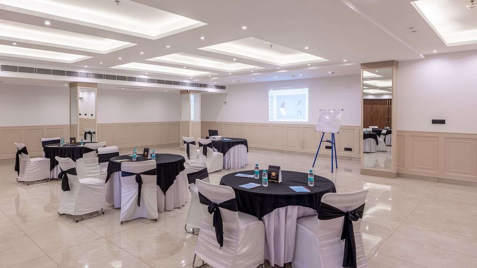 Maahira Conference room at Vishranti Hotel dehradun with chairs and tables covered in black and white cloth and ambient lighting
