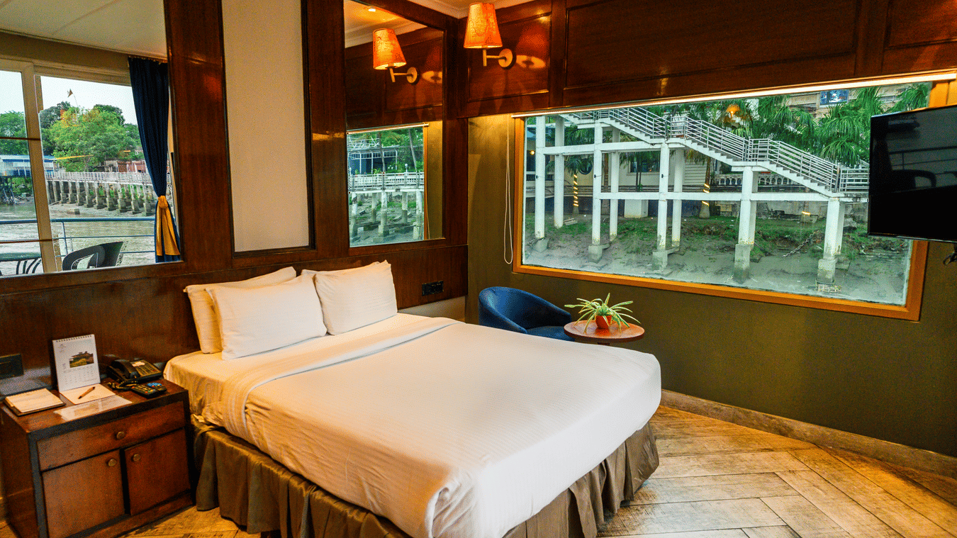 A double bed with side tables inside one of the rooms at Polo Floatel Kolkata