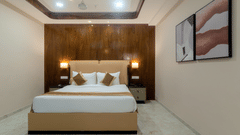 A double bed with side tables and lamps inside the Suite - VITS Satyajeet Karad