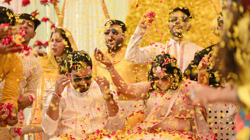 Flower petals being showered at to be bride and groom by their friends and relatives in a Haldi ceremony.