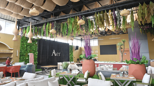 Garden themed restaurant with greenery, vibrant decor, and cosy seating for dining at Pride Elite Raipur.