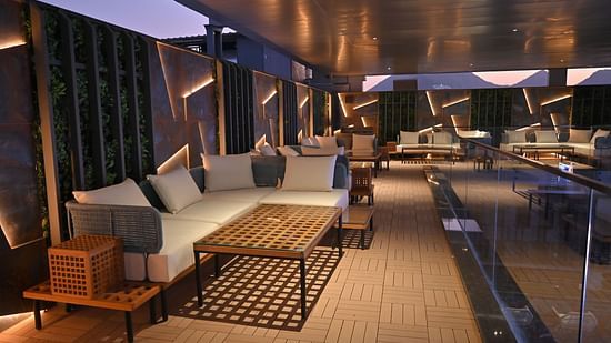 Outdoor rooftop setup with neatly arranged chairs and tables offering a scenic view at Clarks Collection Grand Sapphire, Ajmer.