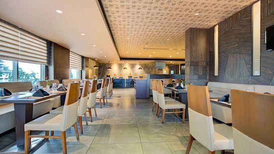 Modern indoor restaurant with elegant seating and ambient lighting at Voyage Milestone Hotel and Banquet Siliguri