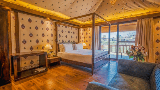 A Premium Duplex Tent featuring  a plunge swimming pool, a sofa set, with centre table, and a flight of wooden stairs at The Baagh Ananta Elite, Ranthambore
