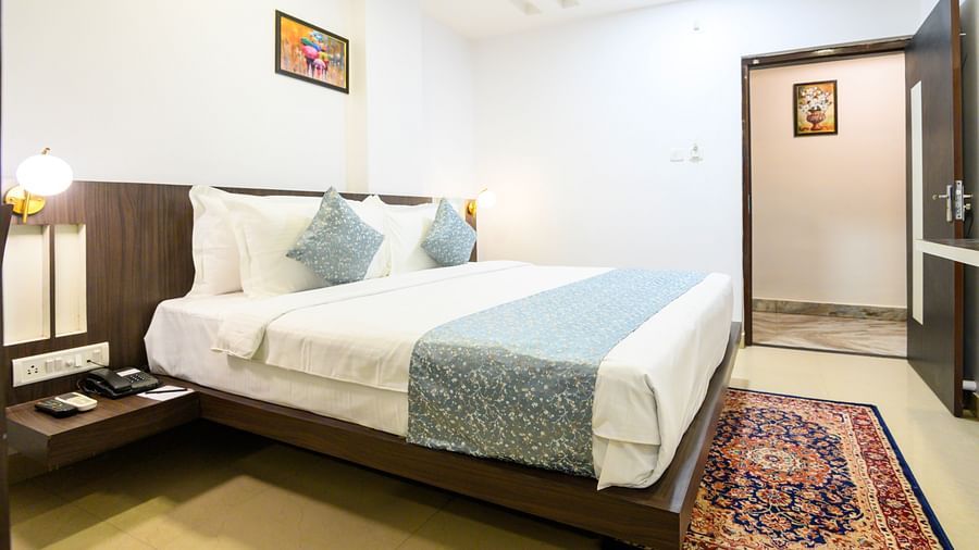 Side view of Deluxe Room featuring a cozy bed and bedside lamp at Biznotel by Pride, Deoghar.
