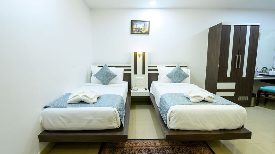 Front view of Deluxe Twin Room featuring two beds and a cupboard at Biznotel by Pride, Deoghar
