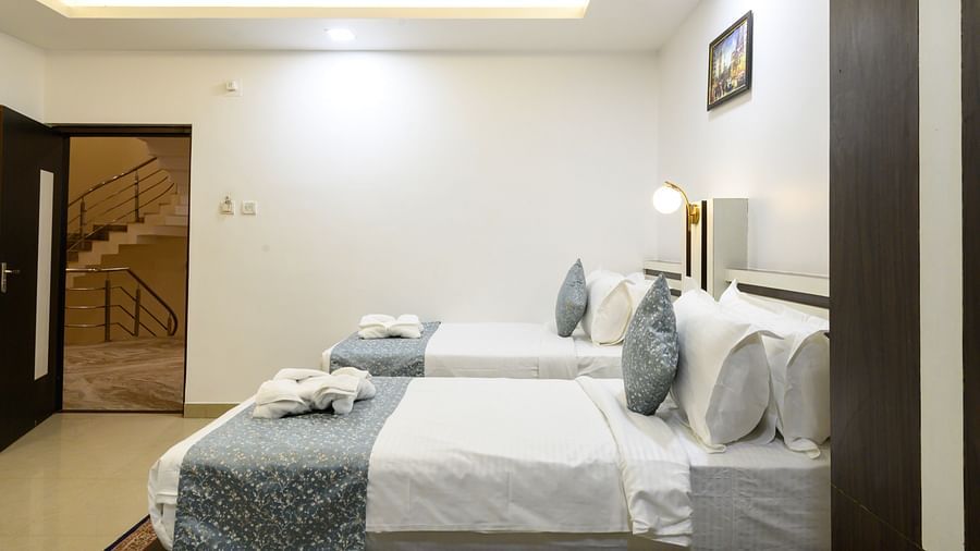 Side view of Deluxe Twin Room featuring two beds and modern decor at Biznotel by Pride, Deoghar