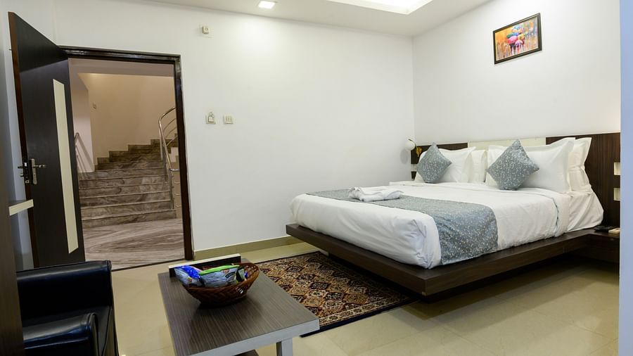 Side view of the Superior King Room showcasing a cozy bed and stylish interior design at Biznotel by Pride, Deoghar
