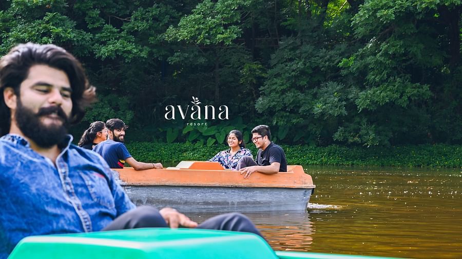 A group of people riding in a paddle boat on a lake or river.