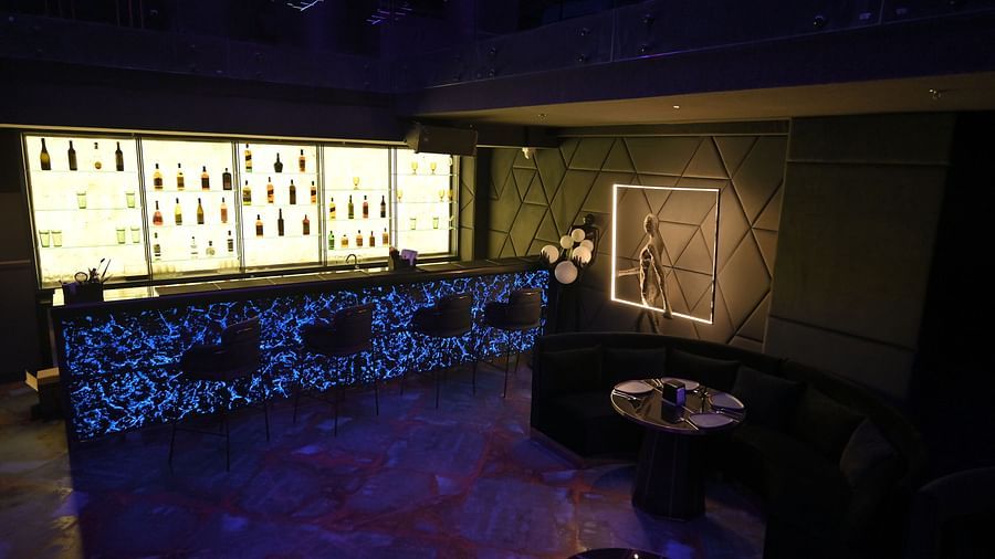 A well-lit bar with bottles neatly arranged on racks at Clarks Collection Grand Sapphire, Ajmer.