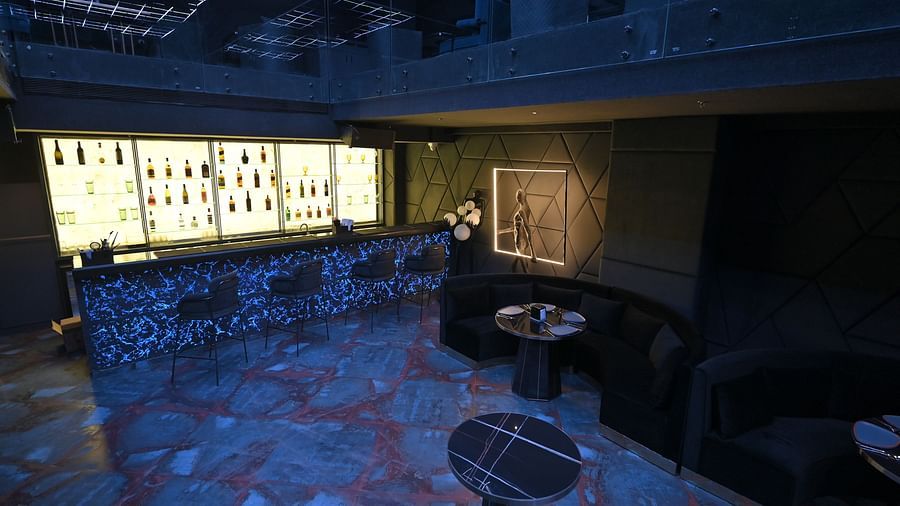 A well-lit bar with bottles neatly arranged on racks at Clarks Collection Grand Sapphire, Ajmer.