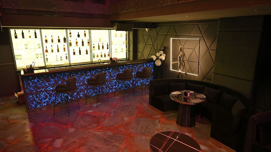 Interior view of the bar with bottles neatly arranged on illuminated racks at Clarks Collection Grand Sapphire, Ajmer.
