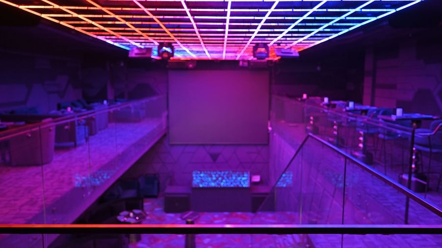 Illuminated staircase lights lead up to a stylish bar with a beautifully designed ceiling at Clarks Collection Grand Sapphire, Ajmer.