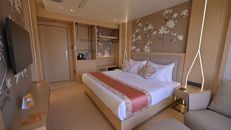 A bedroom with a flower painting above the bed and a doorway in view at Clarks Collection Grand Sapphire, Ajmer.