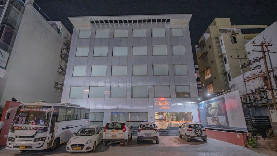The view of Clarks Collection, Vadodara, at night with parked vehicles in front of the hotel building.