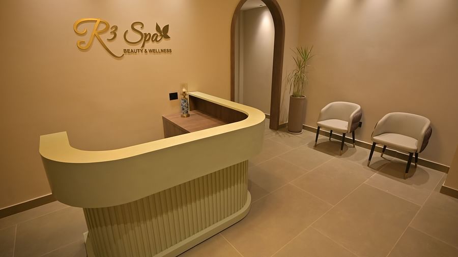 A reception area with a curved light-coloured desk, two chairs, and an arched doorway is shown. - Clarks Safari Haridwar