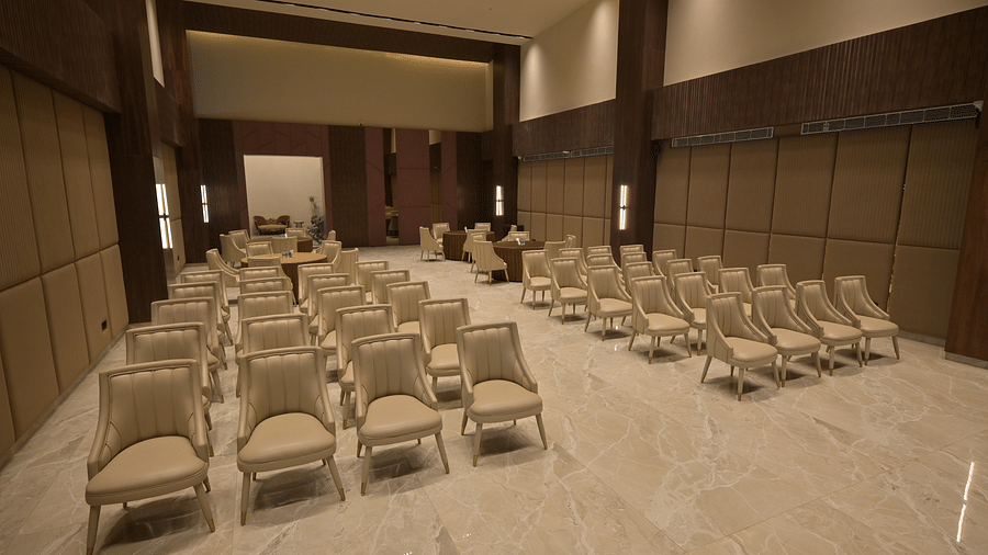 A conference room with rows of chairs facing a stage. - Clarks Safari Haridwar