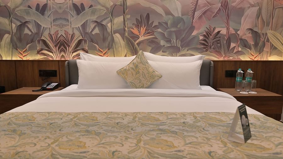 A neatly made bed in Premium Room. - Clarks Safari Haridwar
