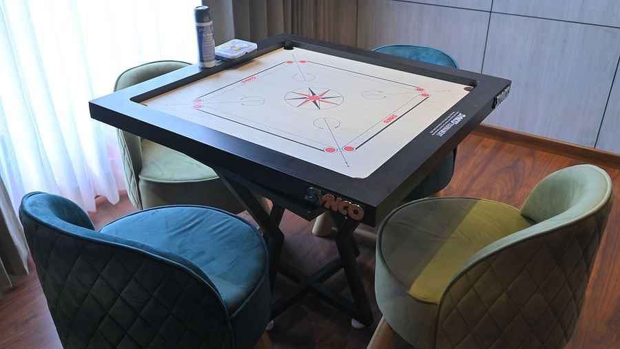 A carrom board table with four chairs on each side, in a bright room - Clarks Safari, Haridwar