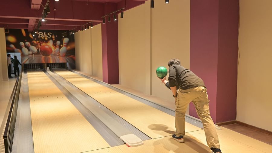 A man throwing a bowling ball in an alley, captured mid-action - Clarks Safari, Haridwar
