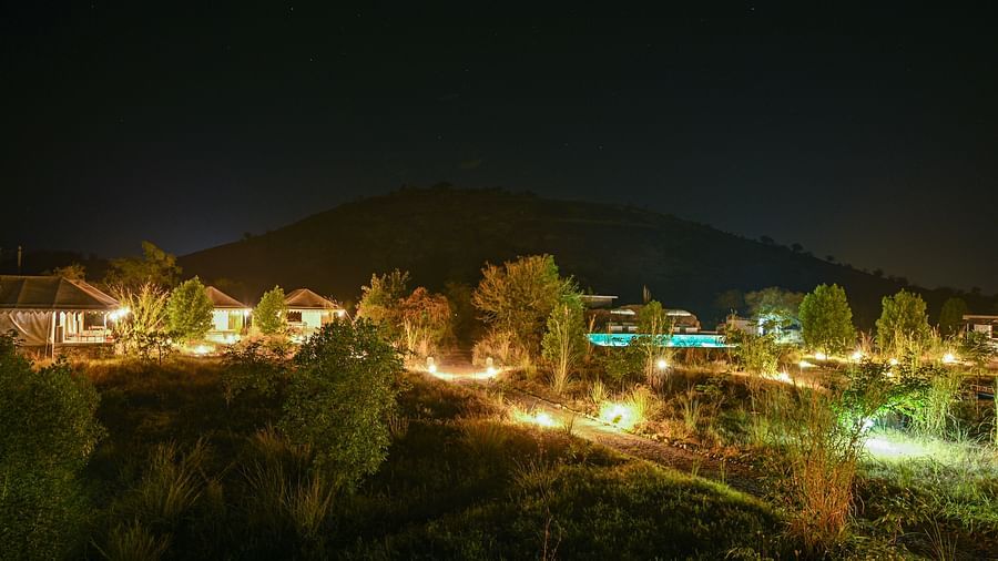Night view of Clarks Safari, Jawai with warmly lit cottages nestled in the hills.