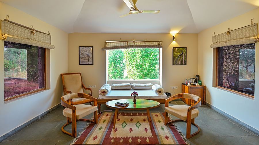 Spacious sitting area with large windows and traditional decor at Clarks Safari, Jawai.