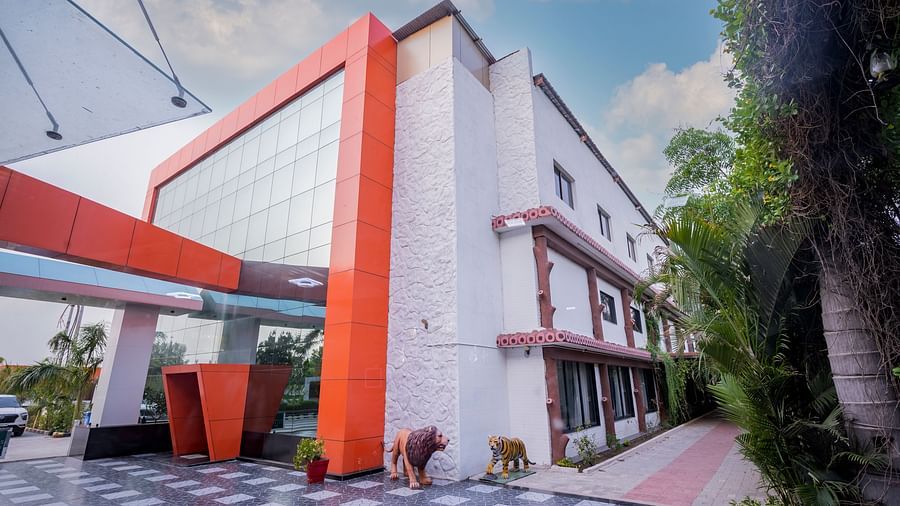 The view of Clarks Safari Kheda, a modern building with striking accents, set against a blue sky with some greenery.