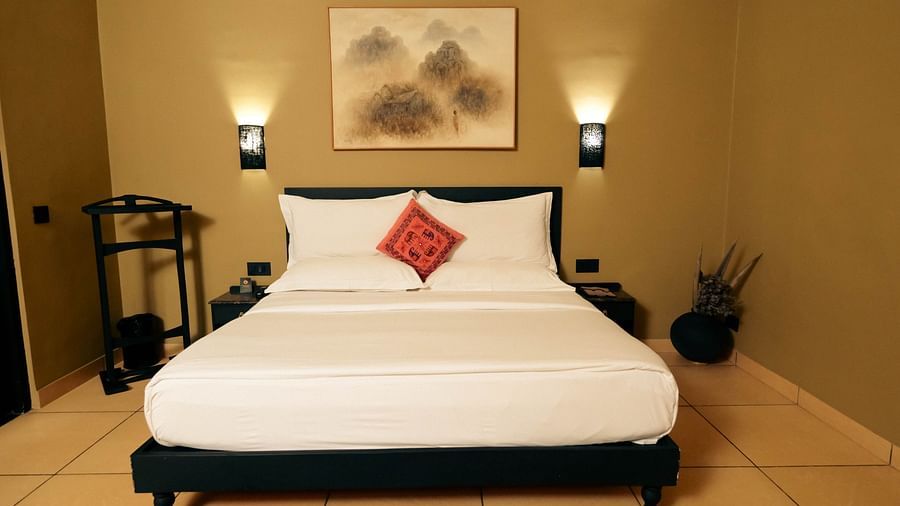 Deluxe King Cottage at Clarks Safari Pushkar featuring a plush bed with fresh linen and two nightstands on both sides under warm lighting