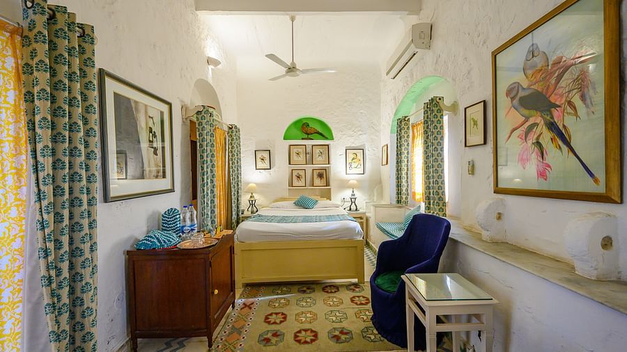 Hill Fort Kesroli 14th Century Alwar - interior view of the Tota Mahal - Garden View - Garden View with single bed, paintings on the wall and green curtains
