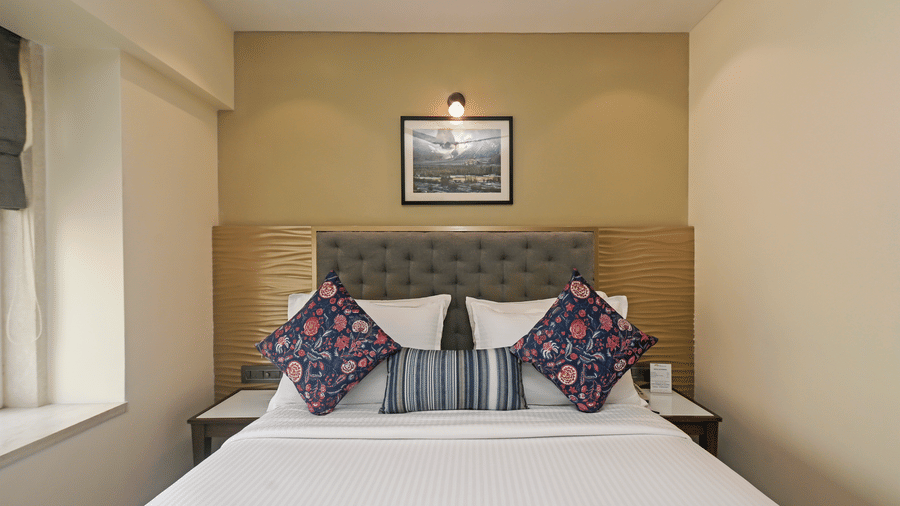 Superior Room at Hotel Le Grande featuring a queen size bed, white duvet, and decorative blue and red pillows