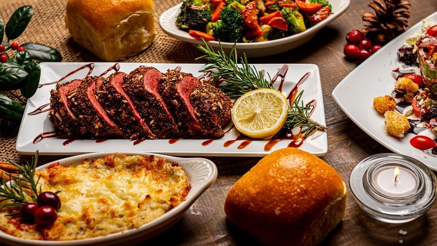 numerous food items on the table for a Christmas feast that includes different meats and veggies