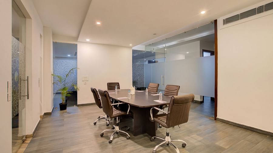 Elegant boardroom setup with a meeting table and executive chairs in a professional setting at Voyage Milestone Hotel and Banquet Siliguri