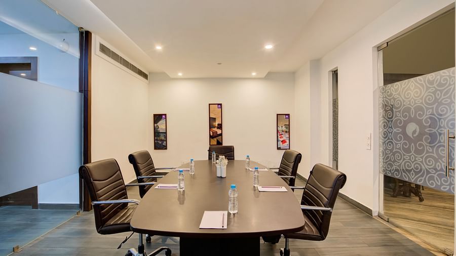 Private meeting space with a sleek conference table, stylish wall art, and ambient lighting at Voyage Milestone Hotel and Banquet Siliguri