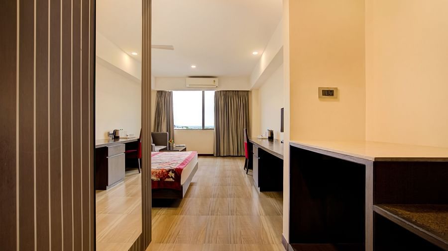 Suite-style room with a partitioned layout, wooden flooring, and modern amenities at Voyage Milestone Hotel and Banquet Siliguri