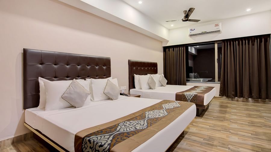 Contemporary room with two large beds, stylish headboards, and wood-patterned flooring at Voyage Milestone Hotel and Banquet Siliguri