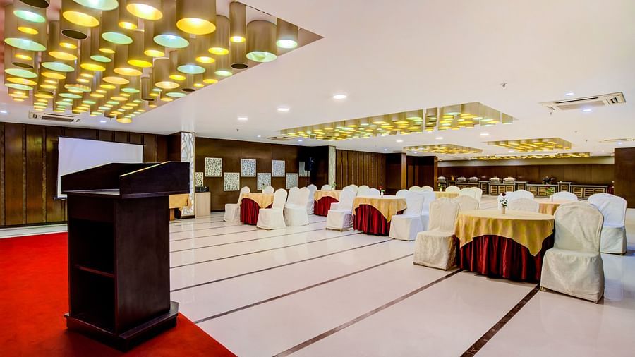 Banquet hall with stage area, ambient lighting, and conference seating arrangement at Voyage Milestone Hotel and Banquet Siliguri.