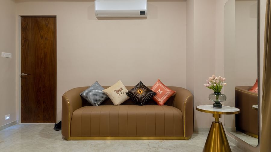 A couch with an AC wall mounted above it inside the Suite - VITS Satyajeet Karad