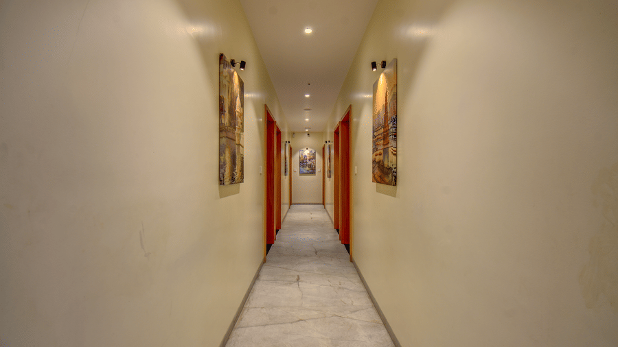 A well-lit corridor of VITS Select Nashik Hotels & Resorts featuring wall hangings facing each other